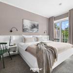 Schlafzimmer mit Bett, Fenster und Blumen