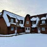 Doppelhaushälfte mit strohgedecktem Dach und Schnee