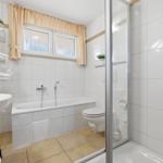 Badezimmer mit Badewanne, Dusche, Toilette und Waschbecken.