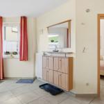 Eingangsbereich mit Garderobe, Spiegel und Blick in Schlafzimmer.