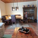 Essbereich mit Holztisch, Stühlen und Sideboard. Holzdecke und Parkettboden.