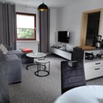Wohnzimmer mit Sofa, TV und Küchenzeile