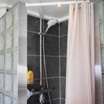 Shower with glass block wall and pink striped curtain