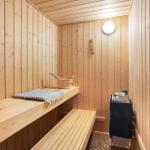 Sauna with wooden walls, bench, and wooden tub with bucket.