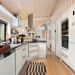 Kitchen with white cabinets, stainless steel stove, and wooden floor.