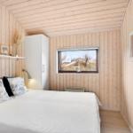 Bedroom with wooden walls, bed, window, and mirror.