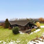 Wooden house with terrace and garden, partially covered in snow.
