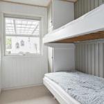 Room with bunk bed, window, and mirror on the wall.