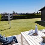 Deck with table, chairs, and view of garden and lake.