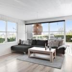 Living room with dark sofa, wooden coffee table, and large windows. Outside is a terrace.
