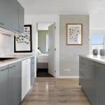 Kitchen with gray cabinets and view into bedroom