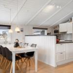 Küche und Essbereich mit weißer Einrichtung und Holzboden.