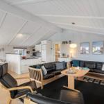 Wohnbereich mit Essbereich, Küche und schwarzen Ledermöbeln.