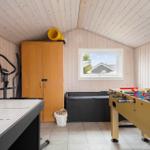 Raum mit Tischfußball, Eisstockschießen und Fitnessgerät.