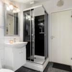 Badezimmer mit Dusche, Waschbecken und Toilette.