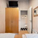 Zwei Betten, Kleiderschrank, TV und Spiegel an den Wänden.