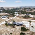 Aerial view of a residential area with multiple houses and winding paths.