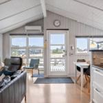 Wohnbereich mit Kamin, Essplatz und Küchenzeile. Durchgang zur Terrasse mit Blick auf den Außenbereich.