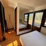 Bedroom with wooden floor, mirrored wall, and windows to the garden