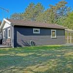A house with gray siding, white windows, and a garden.