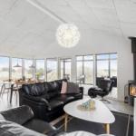 Wohnbereich mit Sofa, Kamin und großem Fensterblick