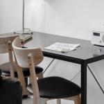 Schreibtisch mit zwei Stühlen, Lampe und Radio.
