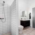 Badezimmer mit Dusche, Waschbecken und Toilette.