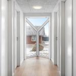 Hausgang mit Holzboden und Glasfront zur Außenterrasse