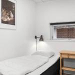 Ein Schlafzimmer mit Bett, Stuhl und Tisch. An der Wand hängt ein Bild.