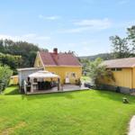 Gelbes Haus mit Terrasse und Garten. Grill und Sonnenschutz vorhanden.