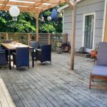 Terrasse mit Holzterrasse, Sitzgruppe und Pavillon mit Hängelampen.