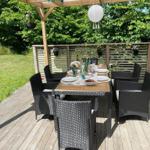 Holzterrasse mit Gedecktem Tisch und Stühlen unter Pavillon.