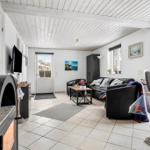 Living room with sofa, fireplace, and large windows.