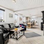 Living and dining area with sofa, coffee table, and kitchen in background.