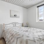 Bedroom with bed, window, and wall art.