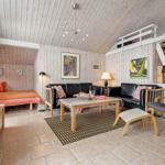 Wohnzimmer mit Sofa, Sessel und Betten unter Dachschräge