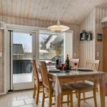 Esszimmer mit Holztisch, Stühlen und Blick auf Balkon. Holzwände und Decke.