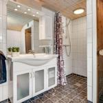 Badezimmer mit Dusche, Waschbecken und Sauna