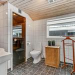 Badezimmer mit Toilette, Waschbecken und Blick in die Sauna.