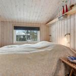 Schlafzimmer mit Holzwand, Bett und Fenster