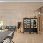 Living area with dining space, sofa, glass cabinet, and view into bedroom