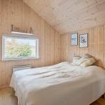 Bedroom with wooden walls, bed, and window.