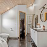 Bathroom with bathtub, toilet, shower, and sink with mirror.