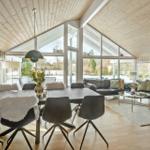 Large living and dining area with wooden ceiling, large windows, and modern furnishings.