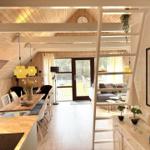 Haus mit Essbereich, Wohnbereich und Terrasse. Holzdecke, Treppe und Fenster sichtbar.