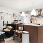 Kitchen with worktop and seating. White walls and wooden elements.