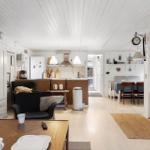 Living kitchen with dining area, white walls, and wooden floor.