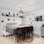 Dining area with table, chairs, and wall shelves. Wooden walls and ceiling. Window with view outside.
