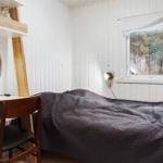 Bedroom with bed, desk, and window to the forest