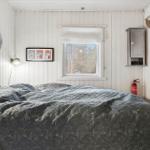 Bedroom with bed, window, and wall decor.